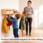 Preview: Montessori Garderobe: Pädagogische Szene der Kindergarderobe in der Kita. Zwei Kinder nutzen selbstständig die Garderobe, die Ablage enthält Mützen. Erzieherin im Hintergrund.