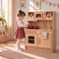 Preview: Mädchen spielt an der Holz Kinderküche GRETEL aus Buchenholz mit Mikrowelle und Herd im hellen Kinderzimmer.