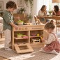 Preview: Kinder spielen an Holz Kinderküche - Eltern sitzen im Hintergrund trinken Kaffee