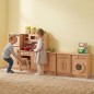 Preview: Kind spielt an einer Montessori Kinderküchenzeile aus Holz, fördert Rollenspiel und Selbstständigkeit
