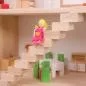 Mobile Preview: Holz-Puppenzhaus Anna mit 2 Etagen, in weiß und natur, Detail: Kinder-Puppe auf Treppe, dahinter Esstisch mit stühlen und Anrichte