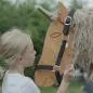Preview: Kind legt dem Holzpferd Einhorn ein Halfter um