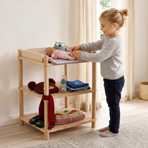 Mädchen füttert eine Babypuppe am Puppen Wickeltisch aus Holz im hellen skandinavischen Kinderzimmer