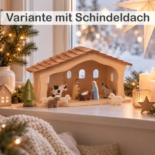 Große Weihnachtskrippe aus Holz mit Schindeldach und Krippenfiguren, weihnachtlich dekoriert auf einer Fensterbank.