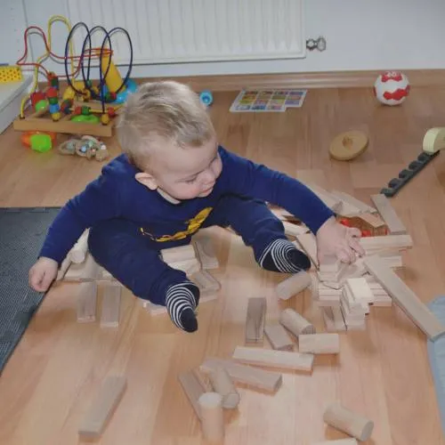 Holzbausteine mit klein-Kind am spielen ab dreijahren