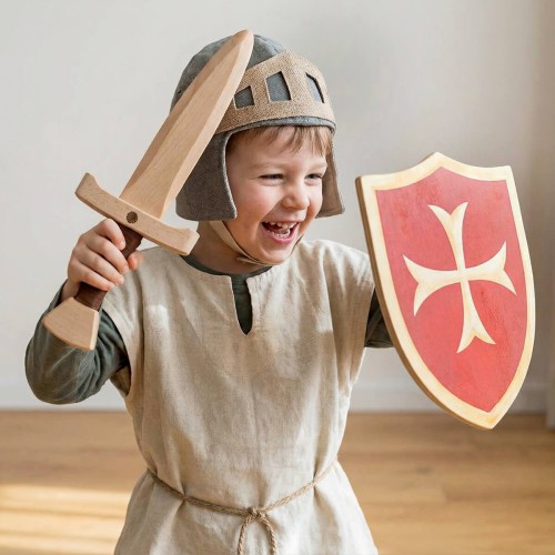 Lachendes Kind spielt Ritter mit Holzschwert und Holzschild aus Holz im Kinderzimmer