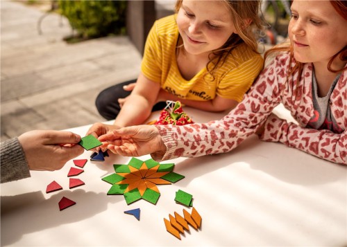 Kinder legen mit LegeART mini ein Mosaik aus Holzplättchen