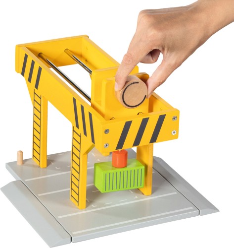 Kind bedient Kurbel am goki Hafenkran und hebt Container magnetisch an