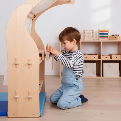 Preview: Werkbank Aufsatz TOBI für Kinder aus Buche Massivholz - mit echter Schraubstock Funktion für Tisch & Spielständer Preview: Werkbankaufsatz aus Buche Massivholz – Kind spielt konzentriert am Spielständer in hellem Kita-Raum, fördert Kreativität.