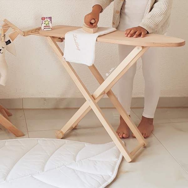 Kind bügelt Kleidung auf Holz Bügelbrett in gemütlicher Szene