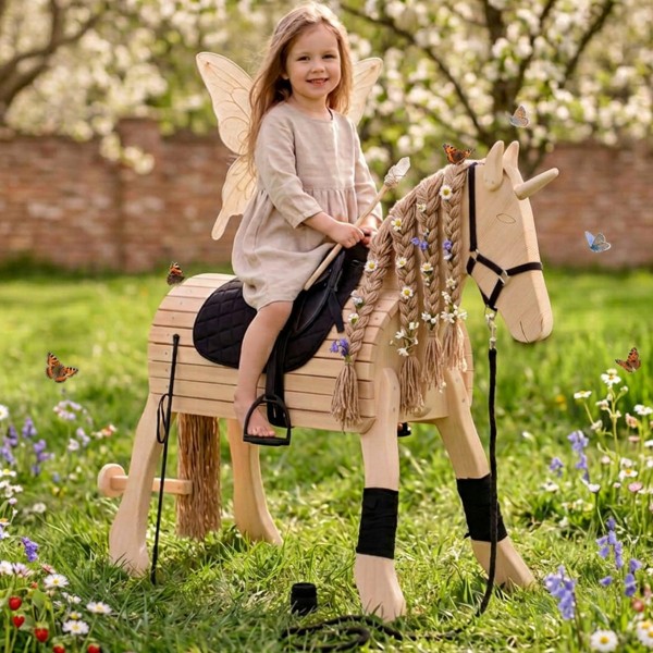 Holzpferd mit Einhorn-Horn steht im Garten – natürliche Integration für fantasievolles Spielen im Freien