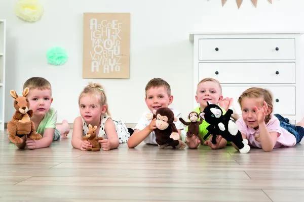 Kinder spielen mit verschiedenen Handpuppen vom Känguruh bis zum Affen und der Katze.