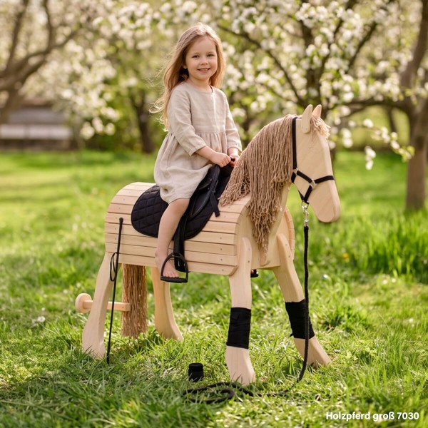 Holzpferd groß - Kind reitet im Garten