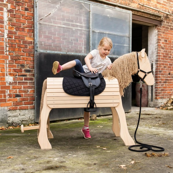 kind steigt auf das Holzpferd