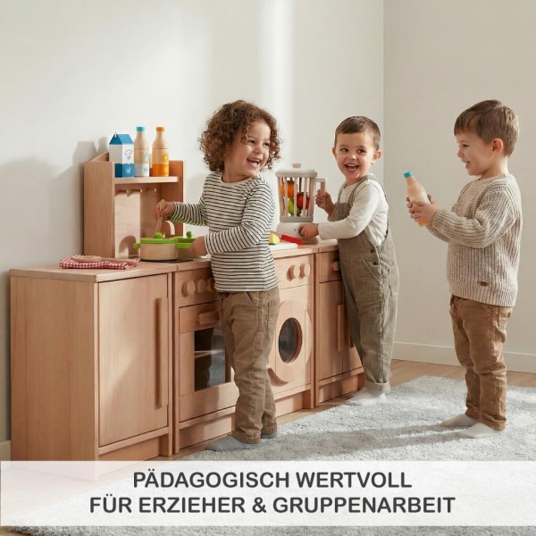 Kita-Kinder spielen gemeinsam an einer Holz Kinderküchenzeile und lernen spielerisch Alltagsabläufe