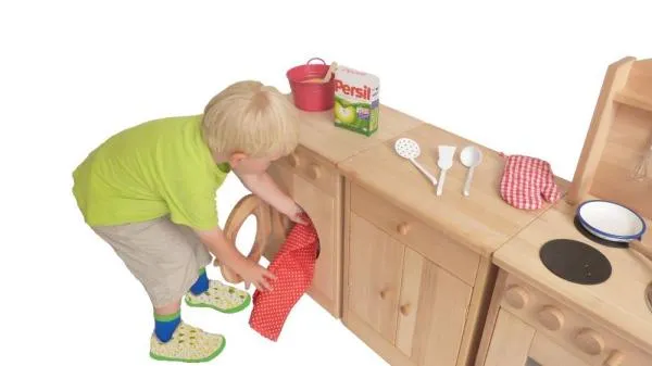 Kind belädt seine Spielwaschmaschine
