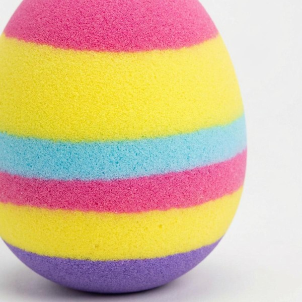 Bunt gestreiftes Holz-Osterei in leuchtenden Farben als Osterdekoration